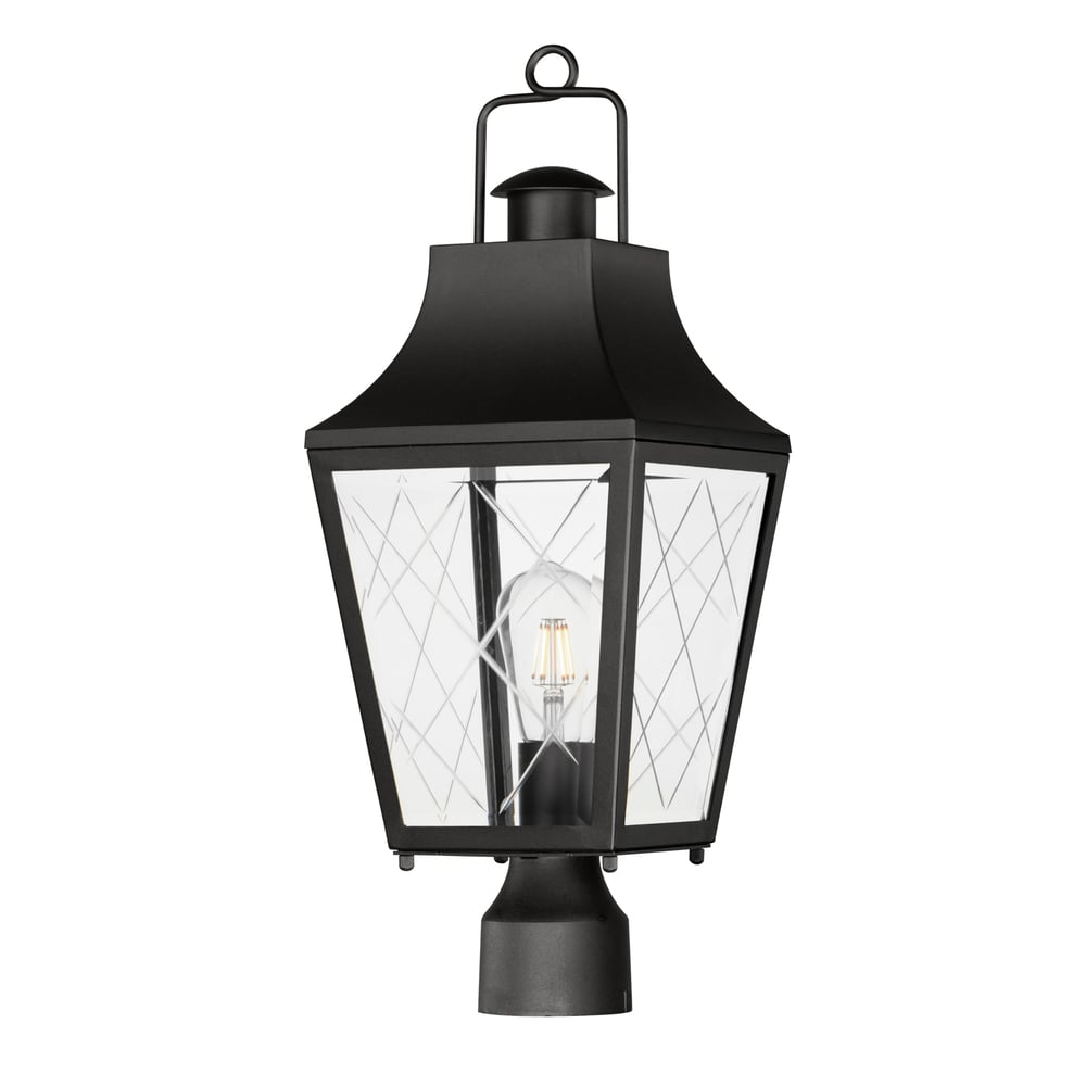 Maxim Lighting Storybook Outdoor Post in black finish, featuring an aluminum frame with glass panels, elegantly illuminates a garden pathway.