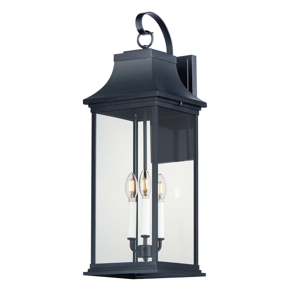 Maxim Lighting Vicksburg Outdoor Wall Sconce in black aluminum with clear glass panels, mounted on a brick wall, illuminating a patio area.