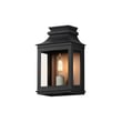 Maxim Lighting Savannah VX Outdoor Wall Sconce in Antique Copper with Black finish, made of Aluminum, mounted on a textured wall, illuminating softly.