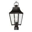 Maxim Lighting Storybook Outdoor Post in black finish, featuring an aluminum frame with glass panels, elegantly illuminates a garden pathway.