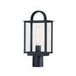 Maxim Lighting Manchester Outdoor Pier Light in Black finish, featuring an elegant Aluminum frame with clear Glass panels, illuminating a garden pathway.