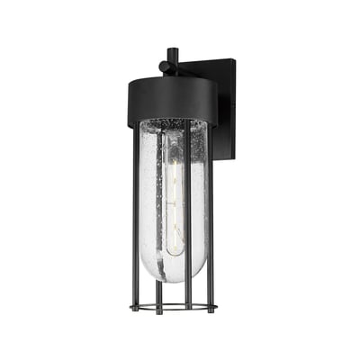 Maxim Lighting Millennial Outdoor Wall Sconce in black aluminum with glass shade, mounted on a brick wall, illuminating a patio area.